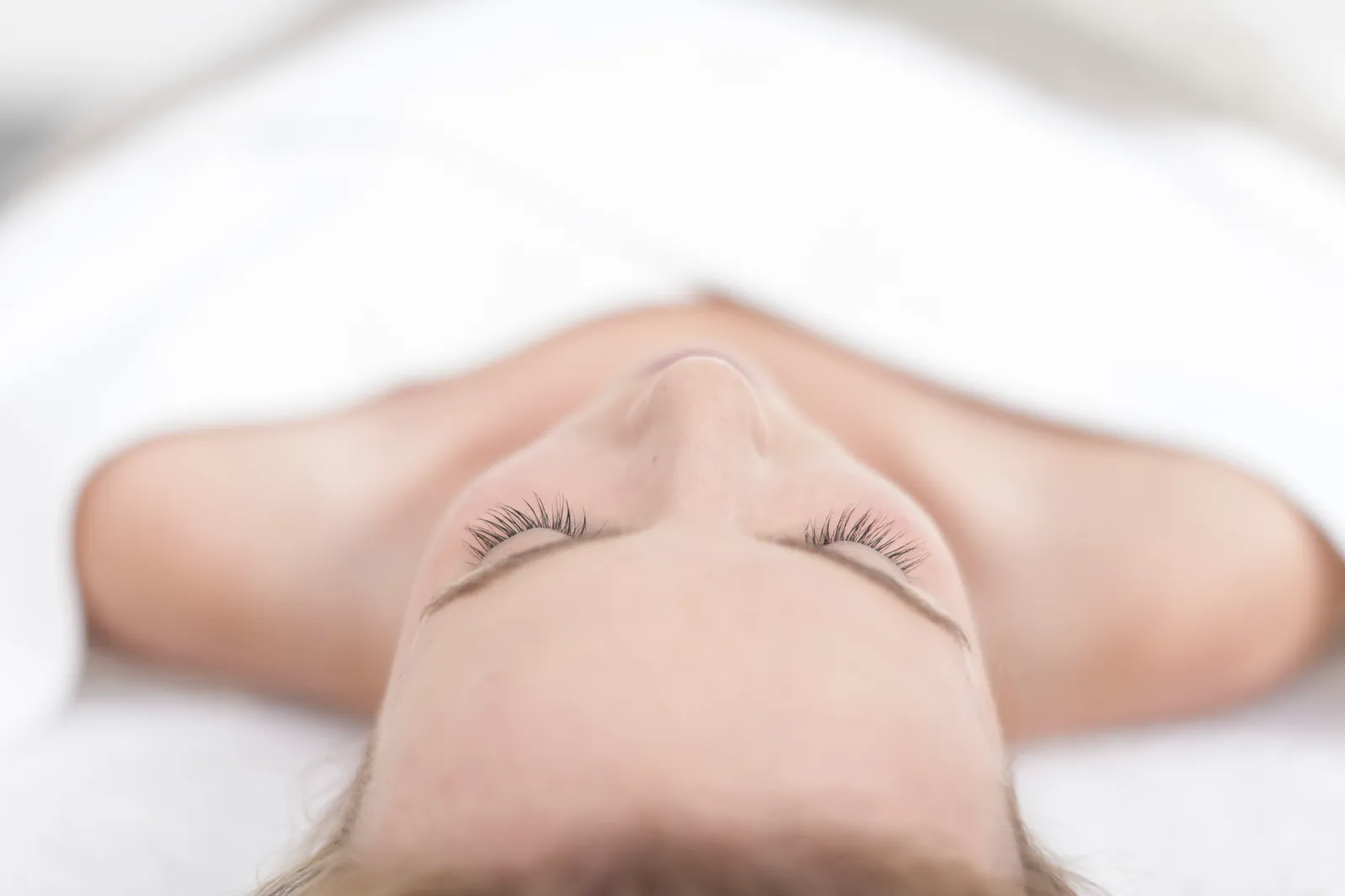 Client relaxing with eyes closed during a facial at Skin Deep Aesthetics in Halifax